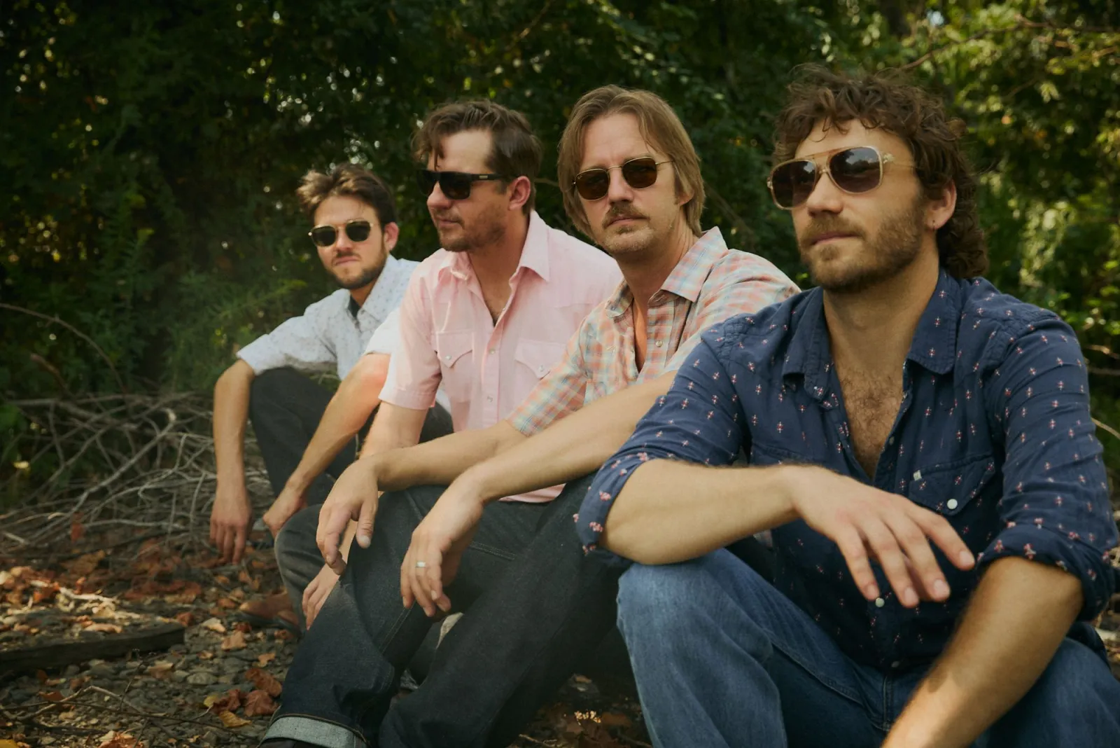 The Fretliners sitting together outdoors in sunglasses